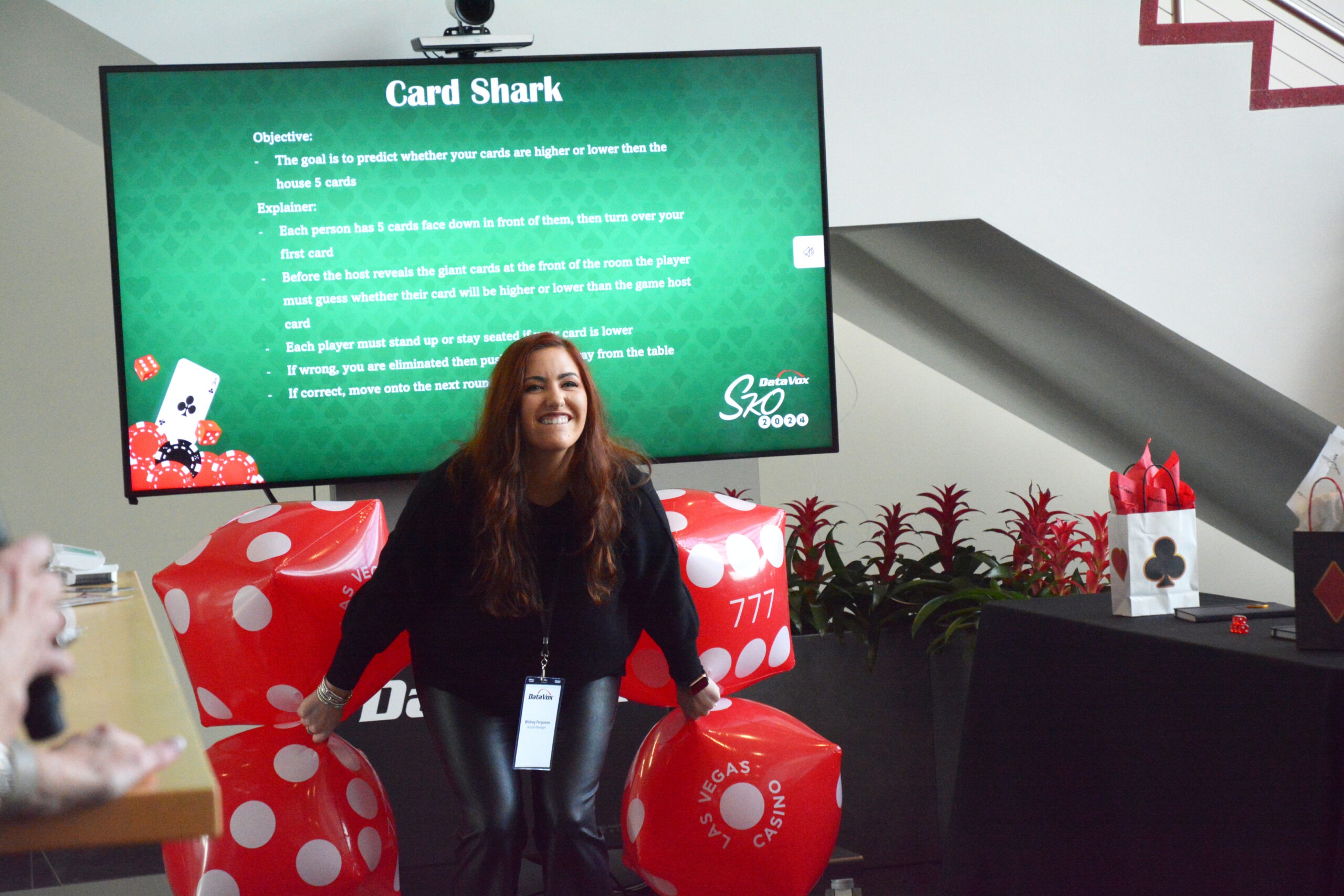 A woman throwing 4 inflatable red die at a previous SKO event