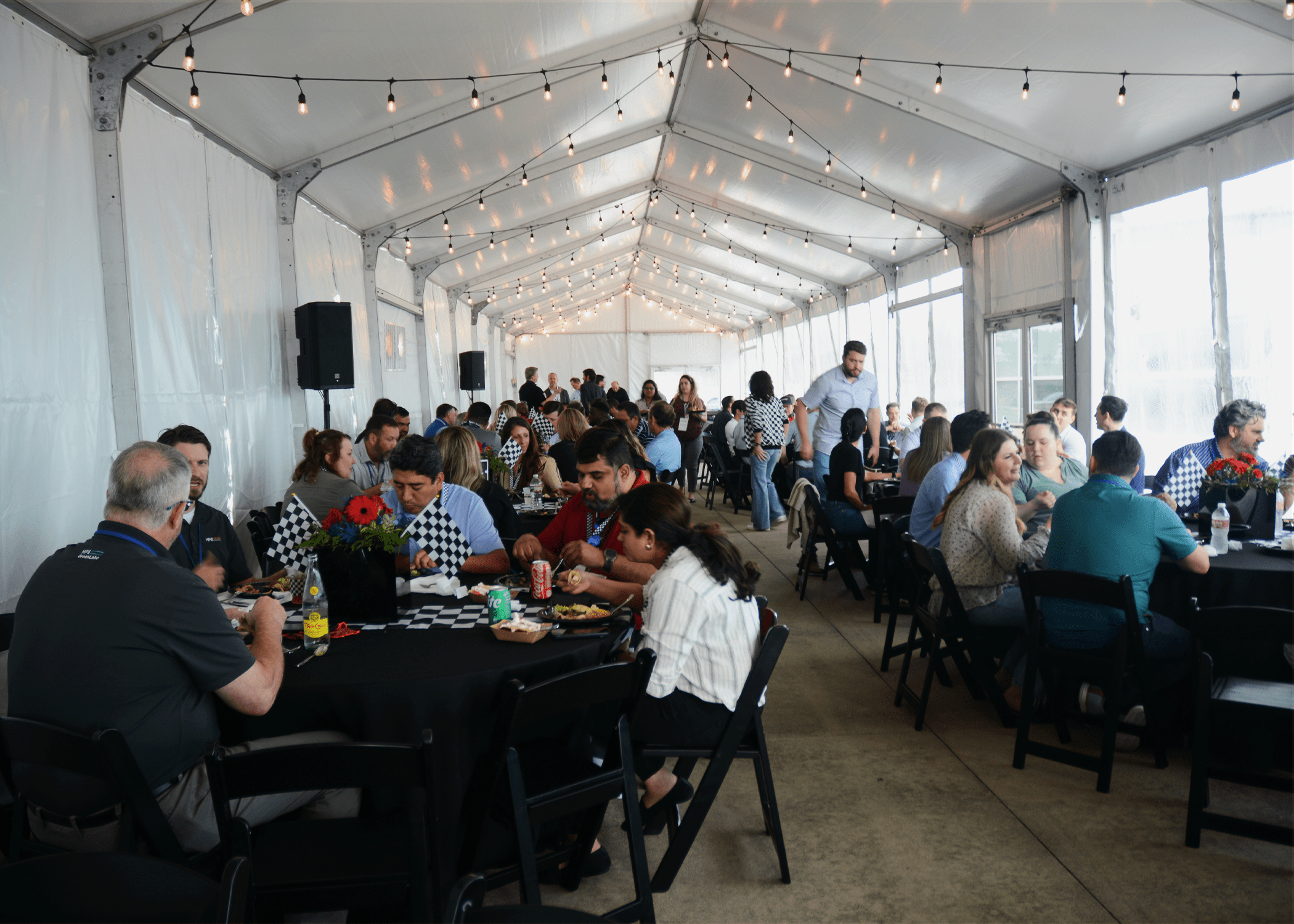 DataVox team members and partners sitting under an event tent sharing a meal during the IT Summit Networking Reception.