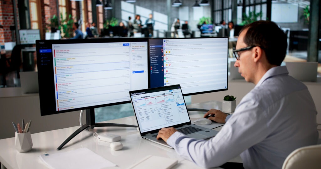 Middle-aged Man Uses Laptop Reviewing CAPA Reports For Process Improvement.